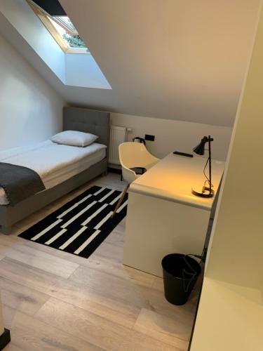 a bedroom with a bed and a desk with a lamp at Pokoje Gościnne Maestro Aleja Krakowska 84 in Sękocin Stary