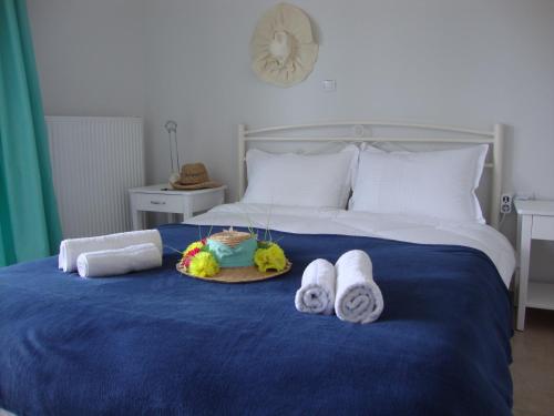 a bed with towels and a plate of food on it at Joy Apartment in Keramotí