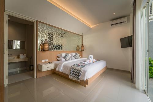a bedroom with a bed and a television in it at Ola Villas at Uluwatu Pecatu in Uluwatu