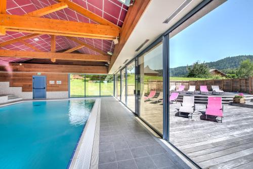 a house with a swimming pool and a deck at Village vacances Chalet de la Haute-Joux in Cerniébaud