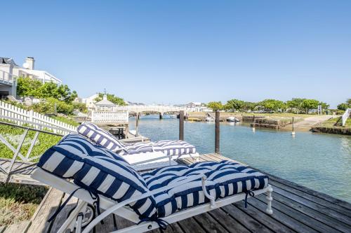 three lounge chairs sitting on a dock next to the water at Canal Waterside Lifestyle on Thesen Islands in Knysna