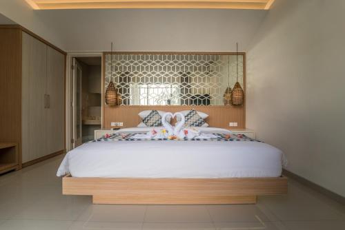 a bedroom with a large white bed with a window at Ola Villas at Uluwatu Pecatu in Uluwatu