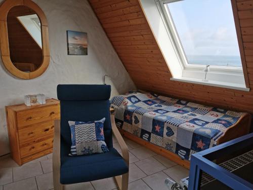 ein Schlafzimmer mit einem Bett, einem Stuhl und einem Fenster in der Unterkunft Ferienwohnungen Traumlage in Kronsgaard