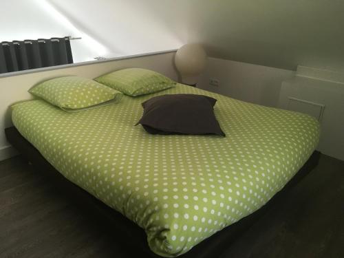 a bed with polka dot sheets and pillows at Les terrasses d'Ornans in Ornans
