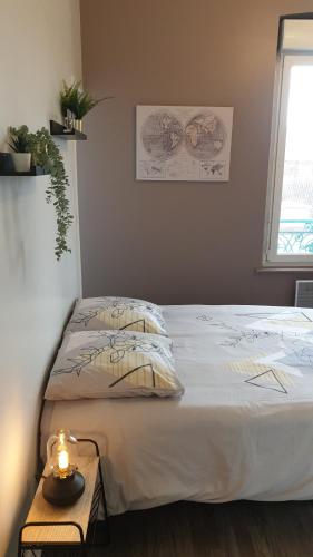 a bedroom with a bed with a candle on a table at Linotin centre ville Compiègne in Compiègne