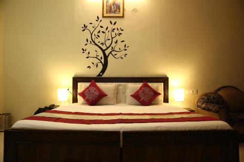 a bedroom with a bed with a tree on the wall at The diamond palace in Chandīgarh