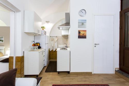 a small kitchen with white cabinets and a sink at Palermo Central Holiday in Palermo