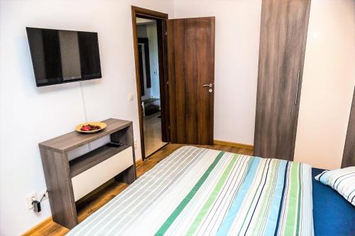 een slaapkamer met een bed en een televisie aan de muur bij Apartament Ira Mamaia Nord in Mamaia Nord – Năvodari