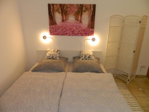 a bedroom with two beds and a painting on the wall at Ferienwohnung Kiko in Zornheim