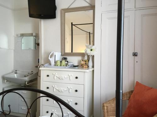 een badkamer met een witte dressoir en een spiegel bij The Haldon Guest House in Paignton