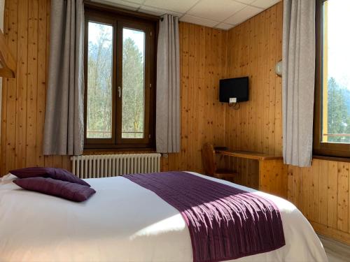 Un pat sau paturi într-o cameră la Hotel des Lacs