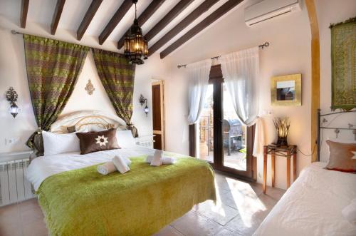 ein Schlafzimmer mit zwei Betten und einem großen Fenster in der Unterkunft Casa Madre Tierra con jacuzzi piscina zona de barbacoa y preciosas vistas in Cómpeta