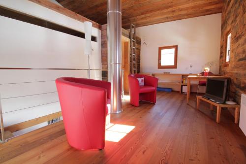 een woonkamer met een rode stoel en een bureau bij Stadel Ritz in Niederwald