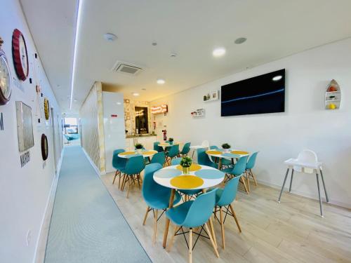 a dining room with tables and blue chairs at Family Hostel Costa Nova in Costa Nova
