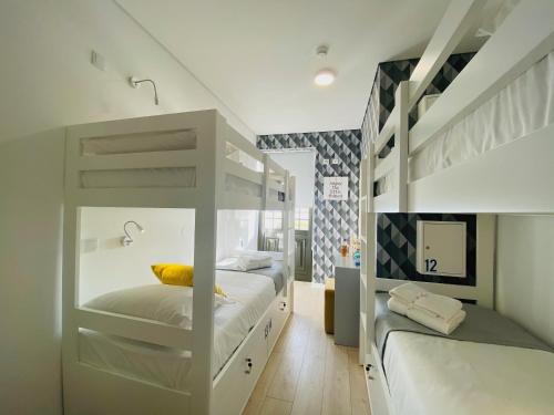 a bedroom with two bunk beds with a yellow pillow at Family Hostel Costa Nova in Costa Nova