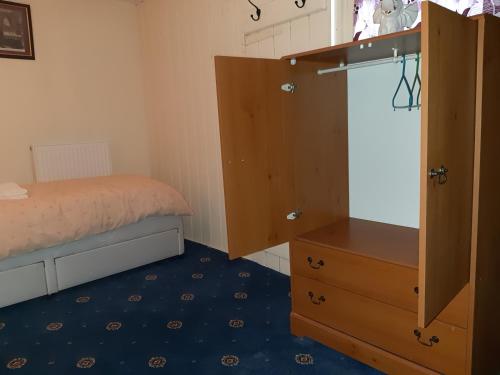 a small bedroom with a bed and a dresser at Phoenix Nights Guest House in Barrow in Furness