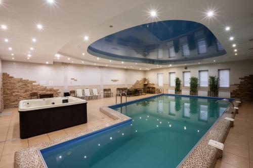 ein großer Pool mit Badewanne in einem Gebäude in der Unterkunft Mirage Hotel in Saratow