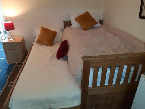 two twin beds in a bedroom with a lamp and a night stand at Phoenix Nights Guest House in Barrow in Furness