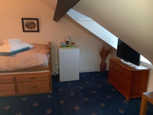 a bedroom with a bed and a tv on a dresser at Phoenix Nights Guest House in Barrow in Furness