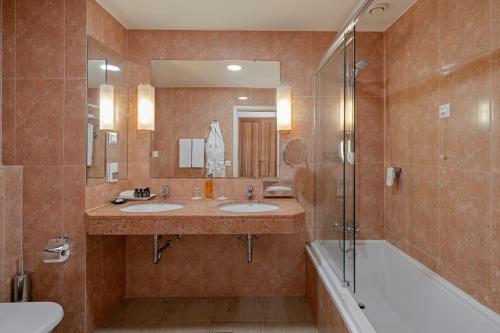
a bathroom with a tub, sink and mirror at Albatroz Beach & Yacht Club in Santa Cruz

