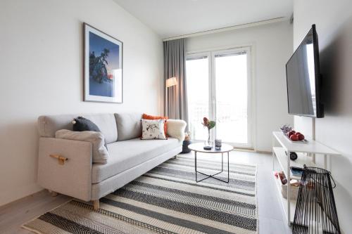 a white living room with a couch and a tv at Tuomas´ luxurious suites, Hilla in Rovaniemi