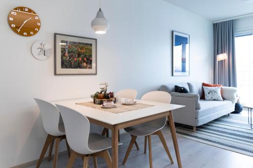 Il comprend une cuisine et un salon avec une table et des chaises. dans l'établissement Tuomas´ luxurious suites, Hilla, à Rovaniemi