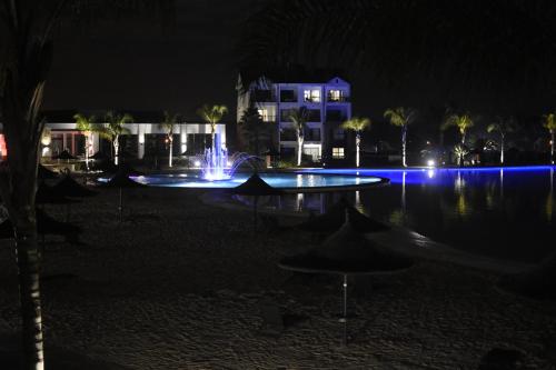 a swimming pool with a fountain at night at The Blyde in Pretoria