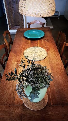 a wooden table with a vase with a plant on it at La Maison Provençale in La Roquebrussanne