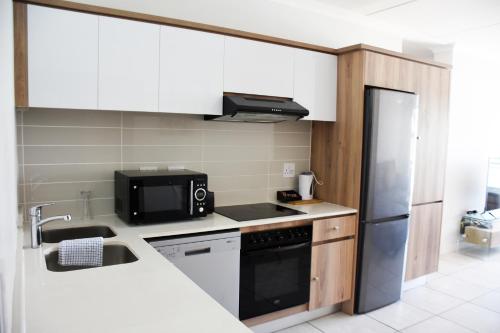 a kitchen with a sink and a refrigerator at The Blyde in Pretoria