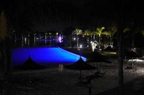 a swimming pool at night with umbrellas at The Blyde in Pretoria