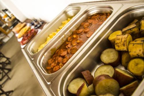 two plastic trays filled with different types of food at Pousada Vila Mar in Itaúnas