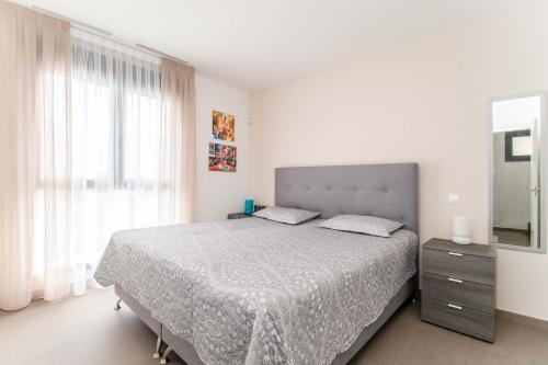 a white bedroom with a large bed and a mirror at Villa de lujo Rojales in Rojales