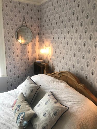 a bedroom with a bed and a lamp and a wall at Craiglands Bed and Breakfast, Grassington in Grassington