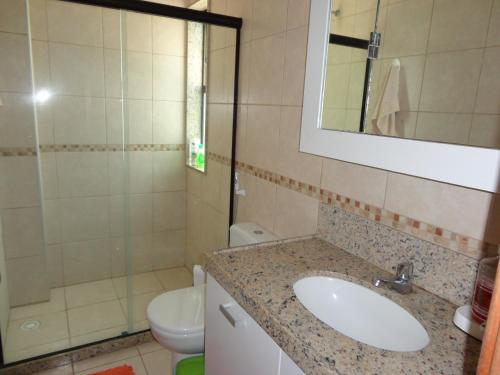 ein Badezimmer mit Waschbecken, Toilette und Spiegel in der Unterkunft BANGALÔ PRAIA DE MURO ALTO/PORTO DE GALINHAS in Porto De Galinhas