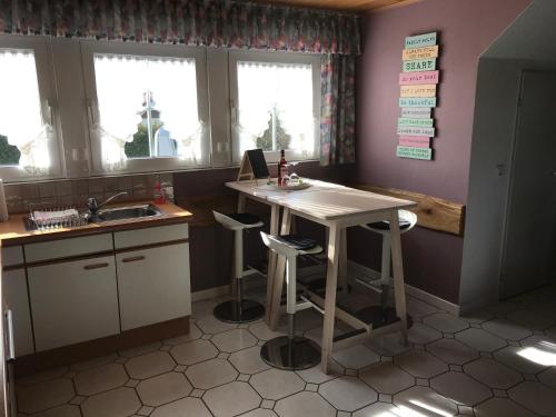 a kitchen with a table and two stools in it at Ferienwohnung Zimmermann in Birkenfeld