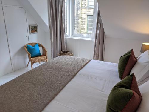 a bedroom with a large white bed and a window at Central Hawick spacious stylish flat with log burner in Hawick