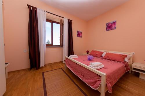 Un dormitorio con una cama con sábanas rojas y una ventana en Kuca Draga - Property Nono, en Opatija