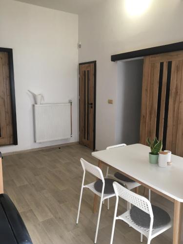 a dining room with a white table and chairs at Apartmán Český Ráj in Jičín