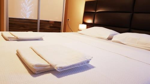 a bed with two white towels on it at Monte Liza in Dobra Voda