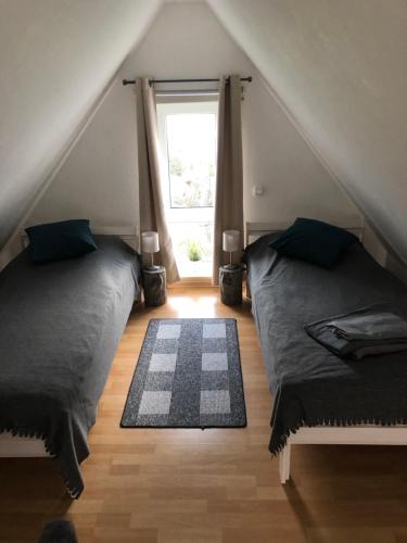a attic bedroom with two beds and a window at Gästehaus Kantelberg in Dahme