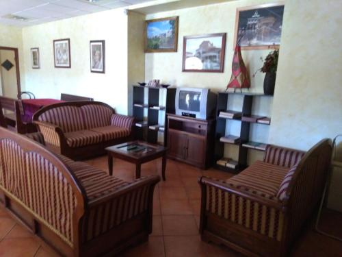 uma sala de espera com sofás e uma televisão em Hotel Sassacci em Civita Castellana