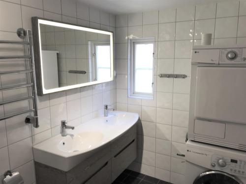 uma casa de banho branca com um lavatório e um espelho em Fogelbergs RyG em Visby