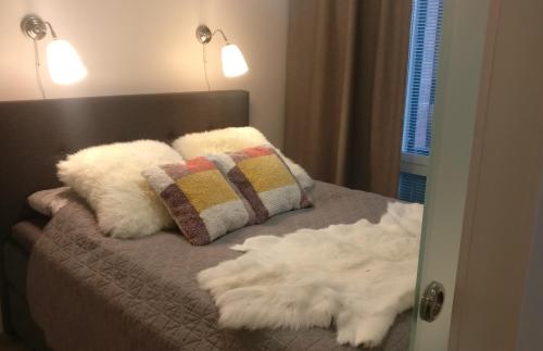 a bedroom with a bed with two pillows and a mirror at Tuomas´luxurious suites, Koivu in Rovaniemi
