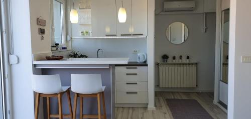 a kitchen with two white chairs and a sink at Bellevue Apartment in Zagreb