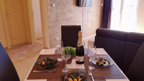 a table with a bottle of wine and wine glasses at Monte Liza in Dobra Voda
