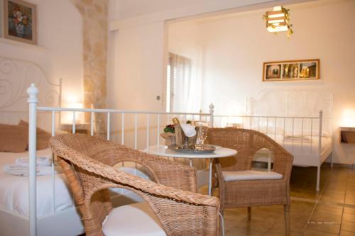 een kamer met een tafel en stoelen en een bed bij B&B Villa Nonna Maria in Castellana Grotte