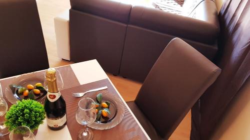 a table with a bottle of wine and fruit on it at Monte Liza in Dobra Voda