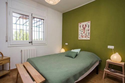 een groene slaapkamer met een bed en een raam bij Jolie Villa vue mer - 100km au Nord de Barcelone - in Pals