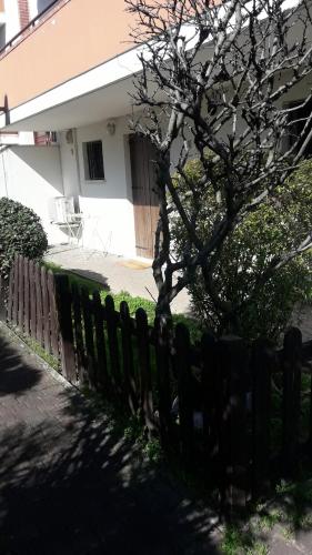 a wooden fence with a tree in front of a house at Ground floor,Top level in Padova