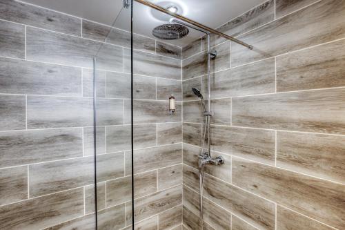 uma casa de banho com chuveiro e azulejos de madeira em Le Petit Magny em Magny-le-Hongre